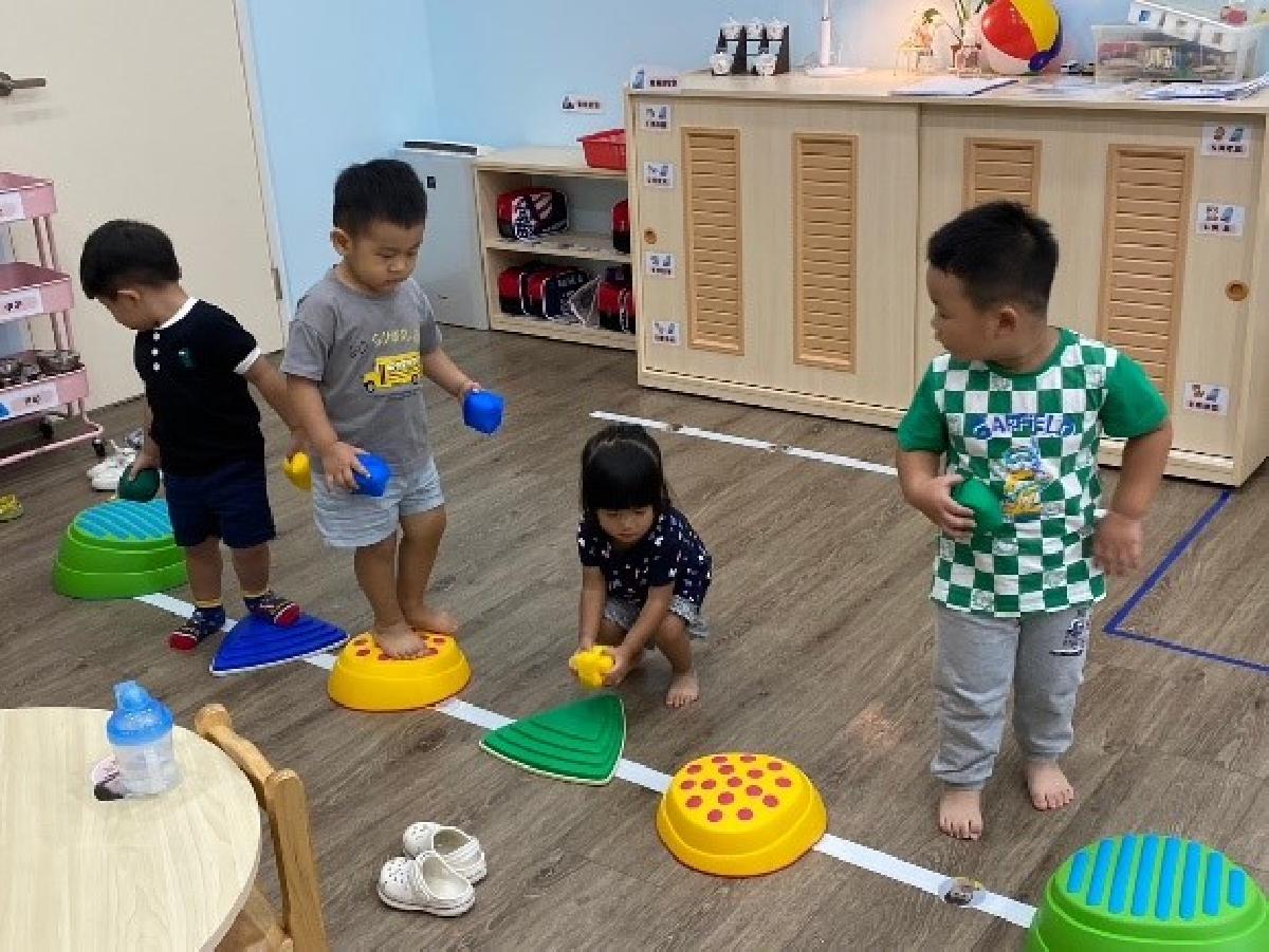 讓幼兒一起合作踩著觸覺石運送球